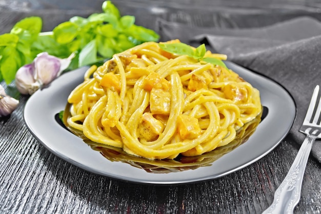 Spaghetti with pumpkin and bacon in plate on board