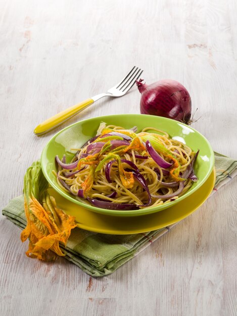 Spaghetti with pumpkin flowers and onions