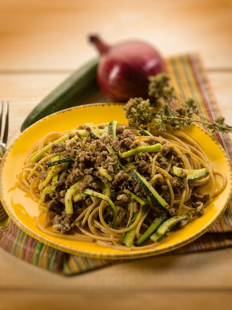 Spaghetti with ragout and zucchinis selective focus