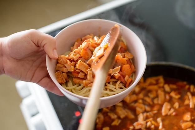 Spaghetti with sauce in the plate. Cooking delicious pasta dishes at home