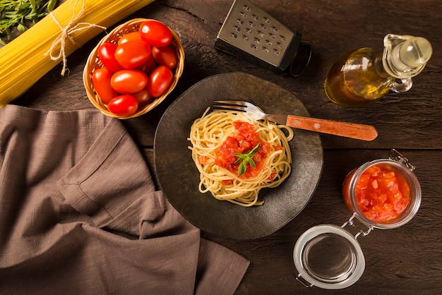 Spaghetti with tomato sauce and basil on the rustic wooden background