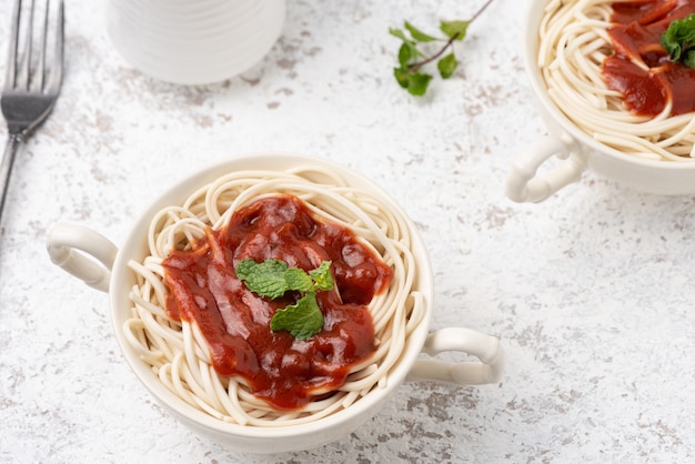 Photo spaghetti with tomato sauce on white