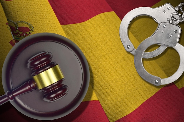 Spain flag with judge mallet and handcuffs in dark room Concept of criminal and punishment background for judgement topics