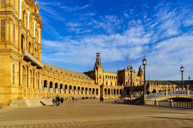 Spain Square in Seville, sunny day with blue sky and white clouds at sunset on a summer day. Golden and orange tones. Andalusia.