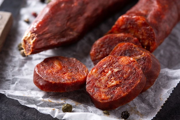 Spanish chorizo sausage on black slate background