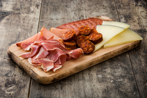 Spanish cold cuts embutidos Cheese, sausage and ham on wooden table