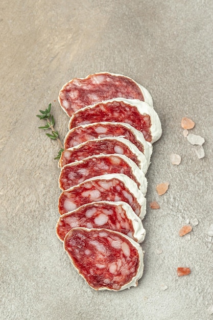 Spanish fuet salami meat on a light background vertical image top view place for text