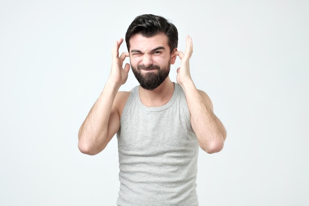 Spanish man covering his ears hands