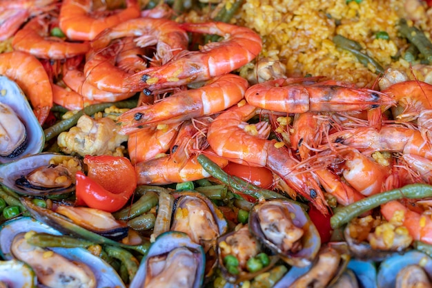 Spanish seafood paella in fry pan with mussels shrimps and vegetables Seafood paella background close up traditional spanish rice dish