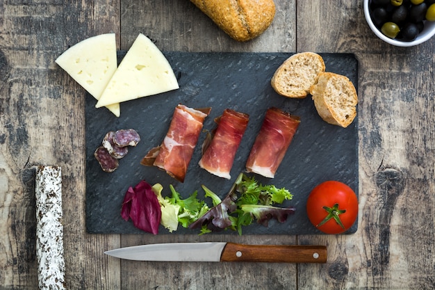 Spanish serrano ham, cheese and sausage on a rustic wooden table