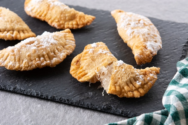 Spanish sweet stuffed pastry filled with angel hair on wooden table