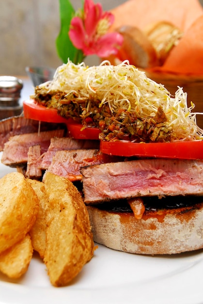 Spanish tapa, pincho or montadito of meat cut with salad and french fries, food