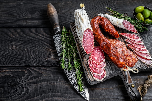 Spanish tapas sliced sausages salami, fuet and chorizo on a wooden cutting board