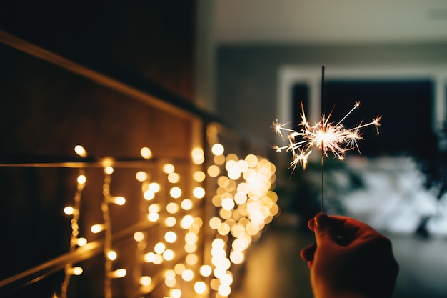 Sparklers on blurred christmas lights. Festive mood. High quality photo