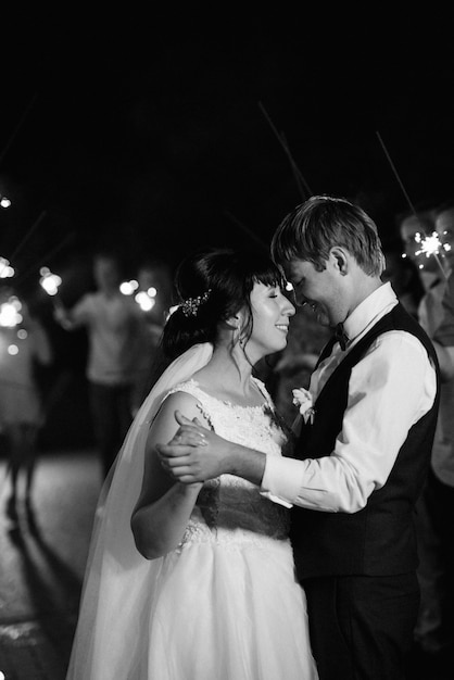 Sparklers at the wedding of the newlyweds in the hands of joyful guests