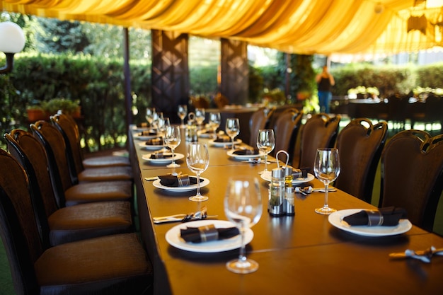 Sparkling glassware stands on long table prepared for wedding dinner