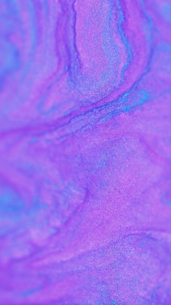 Sparkling ink spill shimmering fluid defocused neon purple blue color shiny glitter particles