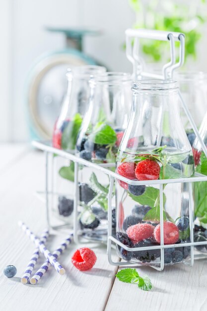 Sparkling soda in bottle with raspberries blueberries and blackberries