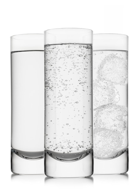 Sparkling and still mineral water with ice cubes and bubbles on white in highball glasses