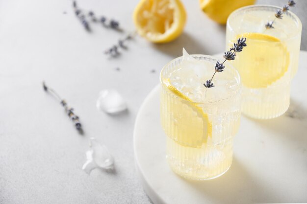 Sparkling summer lavender lemonade in glasses on gray background