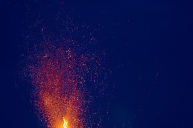 Sparks flying from the fire against the background of the night sky.