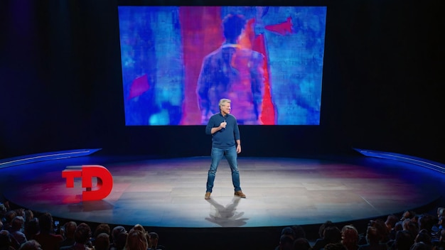 Speaker presenting at a TED event on stage