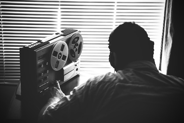 Special agent listens on the reel tape recorder. Officer wiretapping in headphones. KGB spying of conversations.  Cold war period.