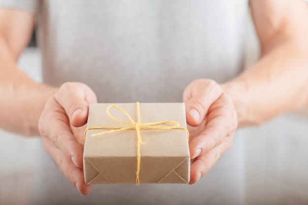 Special day Delivery service Closeup of handmade paper wrap gift box in man hands