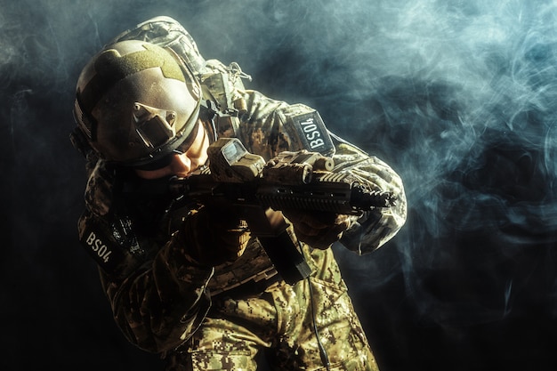 Special forces soldier with rifle on dark background