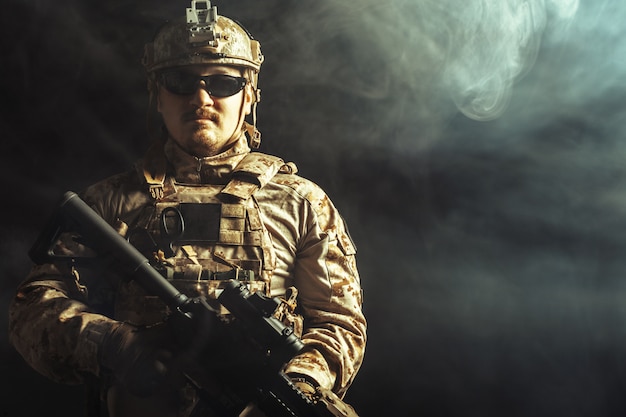 Special forces soldier with rifle on dark