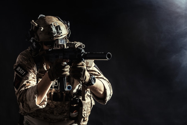 Special forces soldier with rifle on dark