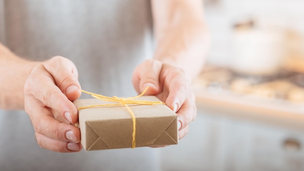 Special occasion Closeup of handmade rustic style gift box in man hands Blur background