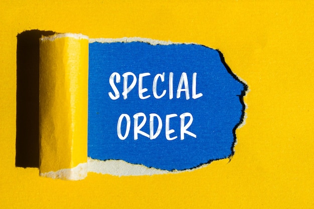 Photo special order message written on ripped yellow paper with blue background conceptual special order symbol copy space