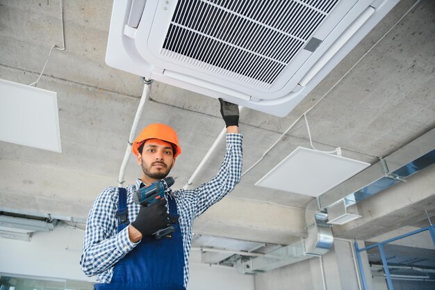 Specialist cleans and repairs the wall air conditioner