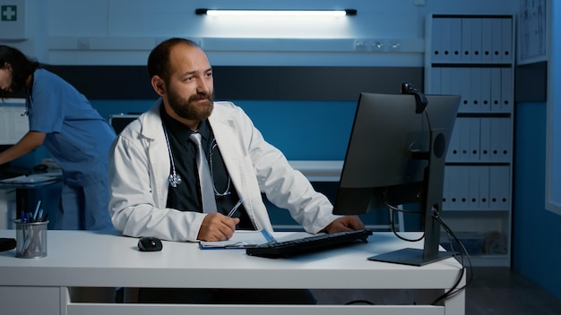 Specialist doctor talking with remote medic during videocall meeting conference discussing patient medical report working over hours at health care treatment in hospital offiice. Medicine service