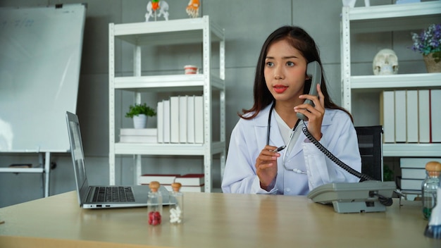 Specialist female doctor talking on the phone Ask the patient for the initial symptoms in order to suggest how to fix the initial problem