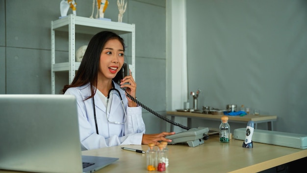 Specialist female doctor talking on the phone Ask the patient for the initial symptoms in order to suggest how to fix the initial problem