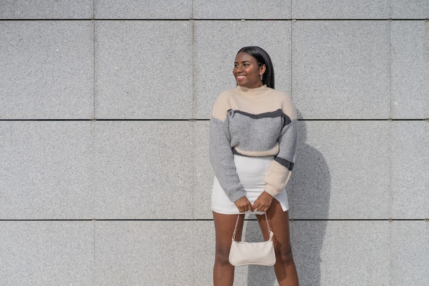 Spectacular and happy young black woman in skirt and sweater