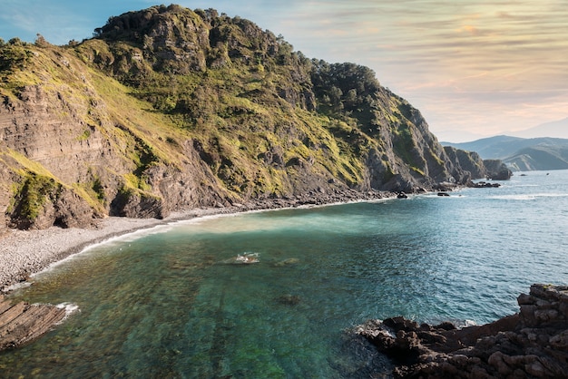 Spectacular scenery of sea and San Juan de Gaztelugatxe island under sunset sky in Spain