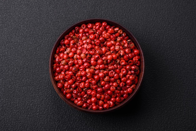 Spice allspice peas of red or pink color in a wooden bowl