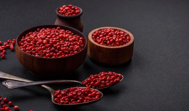 Spice allspice peas of red or pink color in a wooden bowl