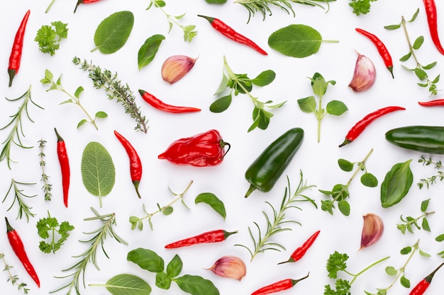 Spice herbal leaves and chili pepper on white. Vegetables pattern. Floral and vegetables on white. Top view, flat lay.