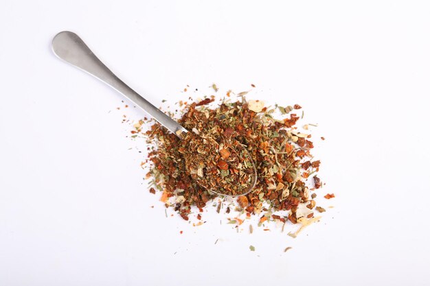 Spice mix natural chopped seasoning for cooking with spoon isolated on white background