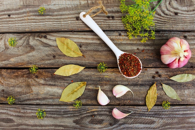 Photo spices, bay leaf, black pepper, garlic and dill on old wooden