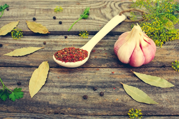 Spices bay leaf black pepper garlic fresh dill on old wooden background