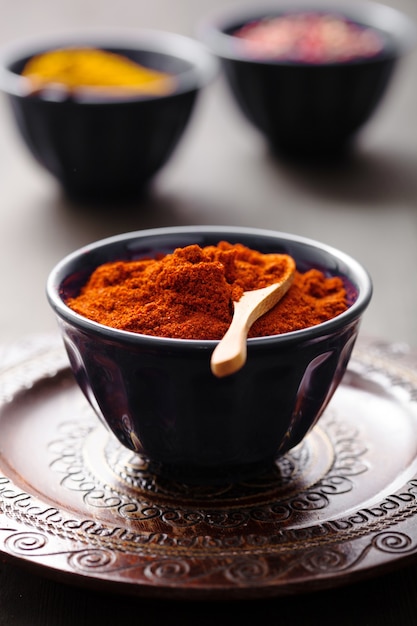 Spices in bowls: curry pink and black pepper paprika powder