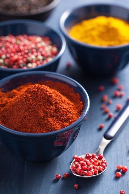 Spices in bowls: curry, pink and black pepper, paprika powder