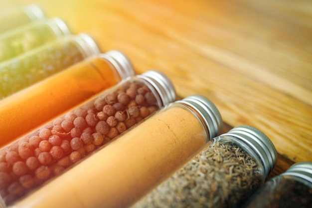 Spices and herbs of different colors in small jars corner view