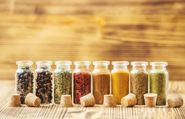 Spices in jars on wooden background. selective focus.