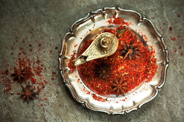 Spices on a vintage plate and lamp oil